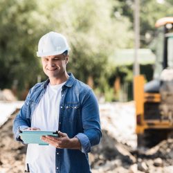 handsome mature construction worker with tablet